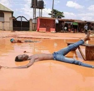 Youths cook and swim in muddy water to raise awareness about the terrible state of a road